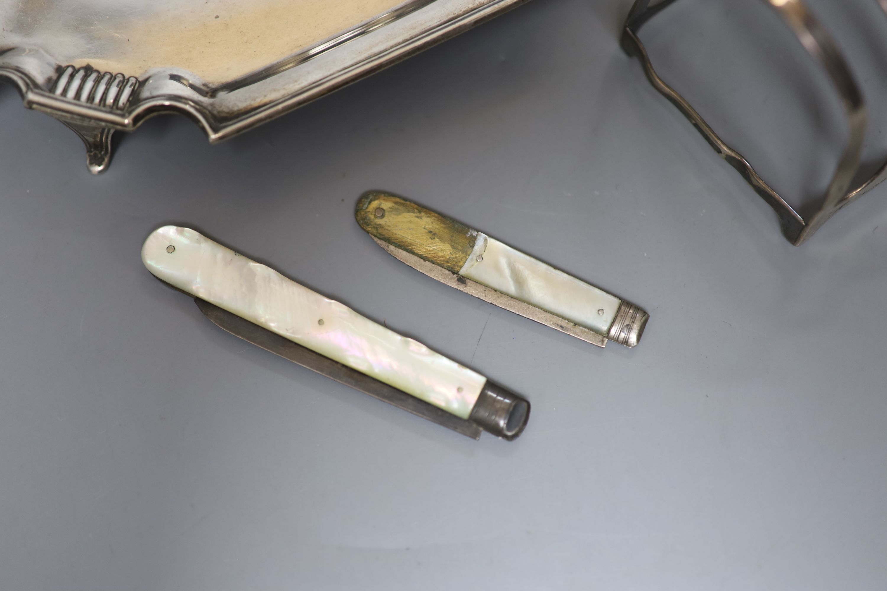 A George V silver seven bar toastrack, a silver inkstand(no well) and two mother of pearl handled fruit knives(a.f.)